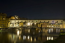 The Ponte Vecchio spanning the Arno river in Florence seen at night from near the entrance to the Uffizzi Gallery