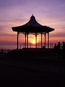 The sun setting over the sea viewed through the Bandstand Blackpool Seafront