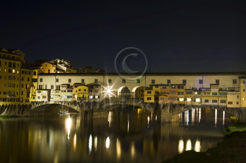 The Ponte Vecchio spanning the Arno river in Florence seen at night from near the entrance to the Uffizzi Gallery